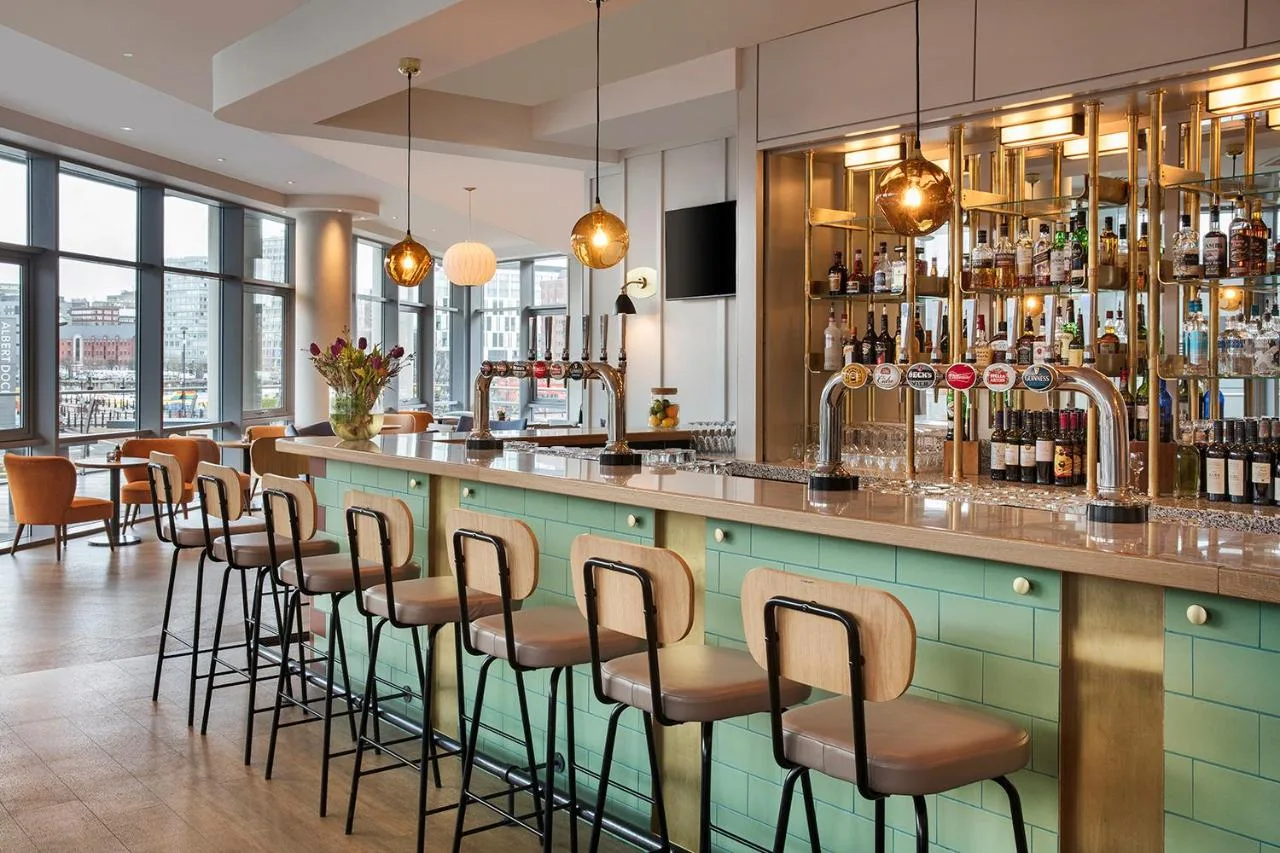 a bar with a row of stools at Leonardo Hotel Liverpool in Liverpool