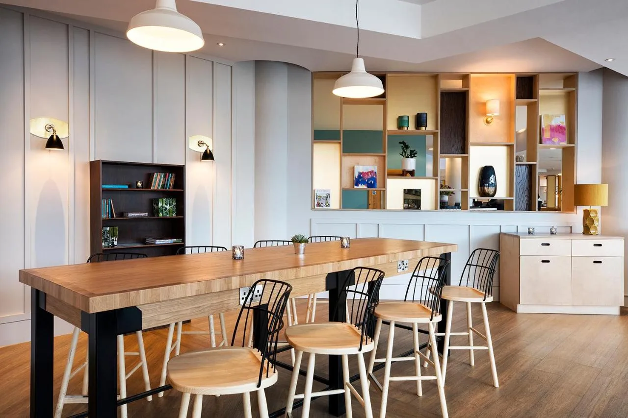 a kitchen with a large wooden table and chairs at Leonardo Hotel Liverpool in Liverpool